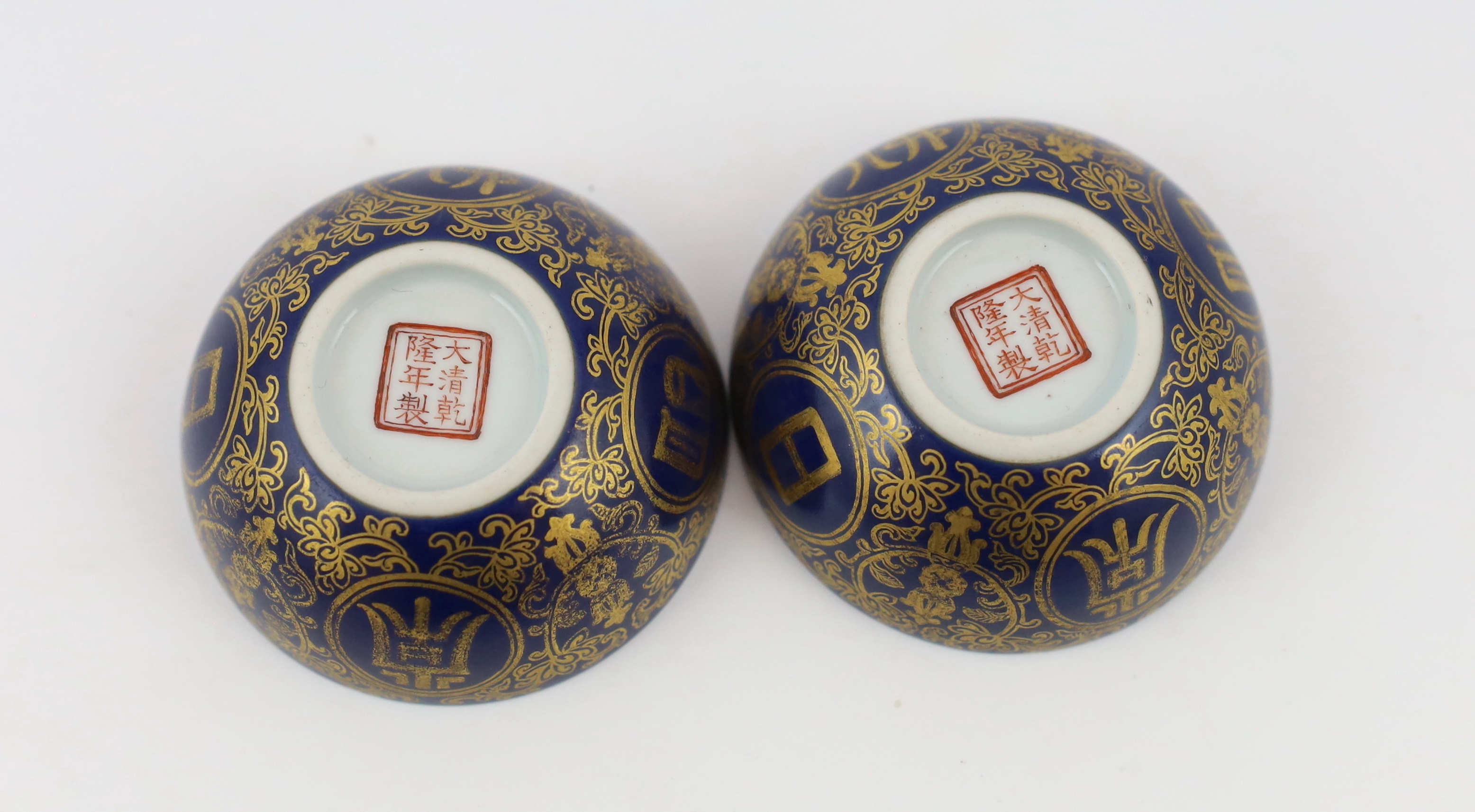 A pair of Chinese gilt decorated blue ground cups, Qianlong mark but later, one cracked